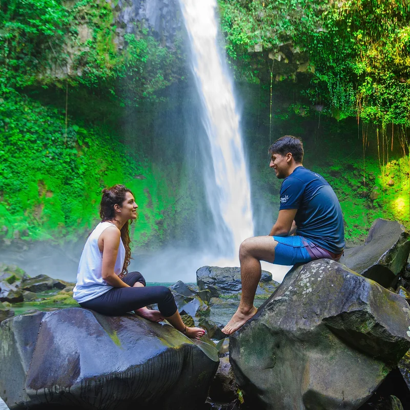 Touristes profitant d'une baignade rafraîchissante au pied de la cascade La Fortuna.
